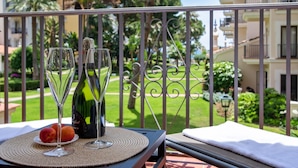 A balcony with a table set for two, featuring a bottle of champagne, two wine glasses, and a plate with fruit. - Gran Terraza ref ADM 116 (Marbella)