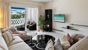 Ein modernes Wohnzimmer mit einer Couch, einem Couchtisch und einem an der Wand befestigten Flachbildfernseher.