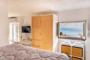 A bedroom with a bed, a TV, a wardrobe, and a window with a view. - [Terrazzasulmare] privateparking-seaview-A/C (Tellaro)