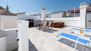 Terraza en la azotea con zona de barbacoa, mobiliario y mesa de billar.