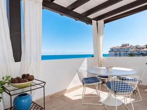 A terrace with a table and chairs, a bowl of pinecones, and a vase. - Br Playas Del Duque Ref C412 (Marbella)