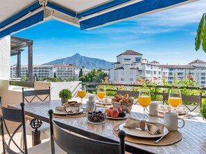 A table set for breakfast with a view of buildings and mountains. - Fant Stico Apartamento con Vistas ref 751 (Marbella)