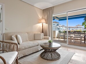 A modern living room with a sofa, a round coffee table, and a view of a balcony with outdoor furniture. - Fant Stico Apartamento con Vistas ref 751 (Marbella)