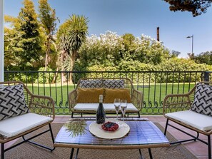 A patio with wicker furniture, a glass table, and a bottle of champagne. - Cerca de la Playa ref Adm409 (Marbella)