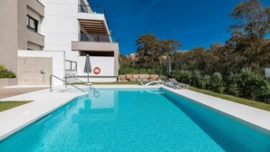 A modern building with a swimming pool, outdoor seating, and a lifebuoy. - Endless Luxury At Marbella Lake Paradise (Marbella)