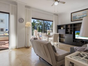 Ein modernes Wohnzimmer mit einer Couch, einem Essbereich und einem Fernseher.
