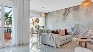 Een moderne woonkamer met een bank, salontafel en een eethoek met stoelen en een tafel.