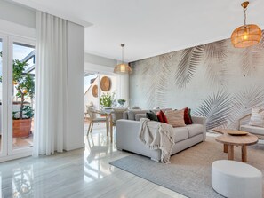 A modern living room with a sofa, coffee table, and a dining area with chairs and a table. - Precioso Tico con Vistas al mar ref 771 (Marbella)