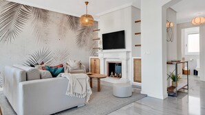 Een moderne woonkamer met een bank, een open haard en een televisie.