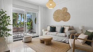 A modern living room with a sofa, armchairs, a coffee table, and a dining area with chairs and a table. - Medina Garden 201 in Puerto Ban s - Marbella (Marbella)