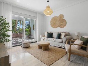 A modern living room with a sofa, armchairs, a coffee table, and a dining area with chairs and a table. - Medina Garden 201 in Puerto Ban s - Marbella (Marbella)