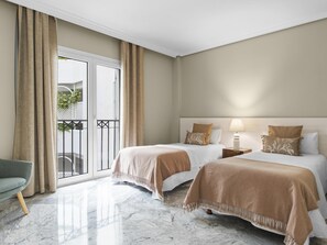 Ein Hotelzimmer mit zwei Betten, einem Balkon und einem Marmorboden.