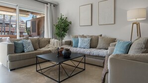 Ein modernes Wohnzimmer mit einer Sofagarnitur, einem Couchtisch und einer Stehlampe.
