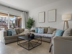 Ein modernes Wohnzimmer mit einer Sofagarnitur, einem Couchtisch und einer Stehlampe.