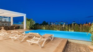 A pool area with lounge chairs and a covered seating area. - Villapadierna Solstice Sanctuary Villa (Estepona)