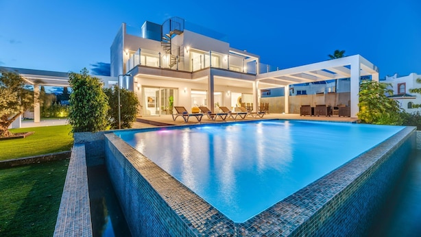 A modern two-story house with a swimming pool, outdoor seating, and a glass staircase. - Villapadierna Solstice Sanctuary Villa (Estepona)