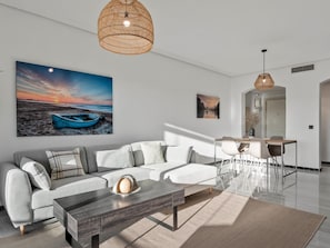 Ein modernes Wohnzimmer mit einer Couch, einem Couchtisch und Kunstwerken an der Wand.