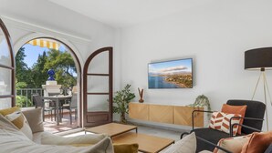 Un saló modern amb un sofà, una taula de centre i una televisió penjada a la paret.