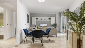 Ein modernes Interieur mit Essbereich, einer Couch und einer großen Pflanze.