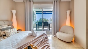 A hotel room with a bed, a chair, a table, and a balcony with a view. - The Diamond Of Puerto Banus With Seaviews (Marbella)