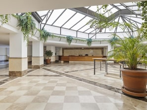 A spacious lobby with a checkered floor, a reception desk, and hanging plants. - Terrazas DE Banus 4 12 (Marbella)