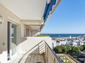 Ein Balkon mit Blick auf das Meer und eine Küstenstadt.