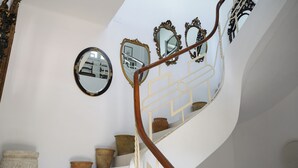 Escadaria com espelhos elaborados e um corrimão de madeira.