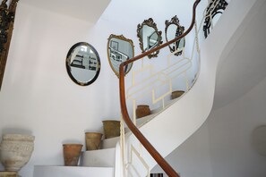 Eine Treppe mit aufwändig verzierten Spiegeln und einem hölzernen Geländer.
