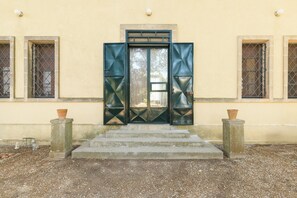 Ein Gebäudeeingang mit einer Treppe, die zu einer Tür mit geometrischen Mustern führt.