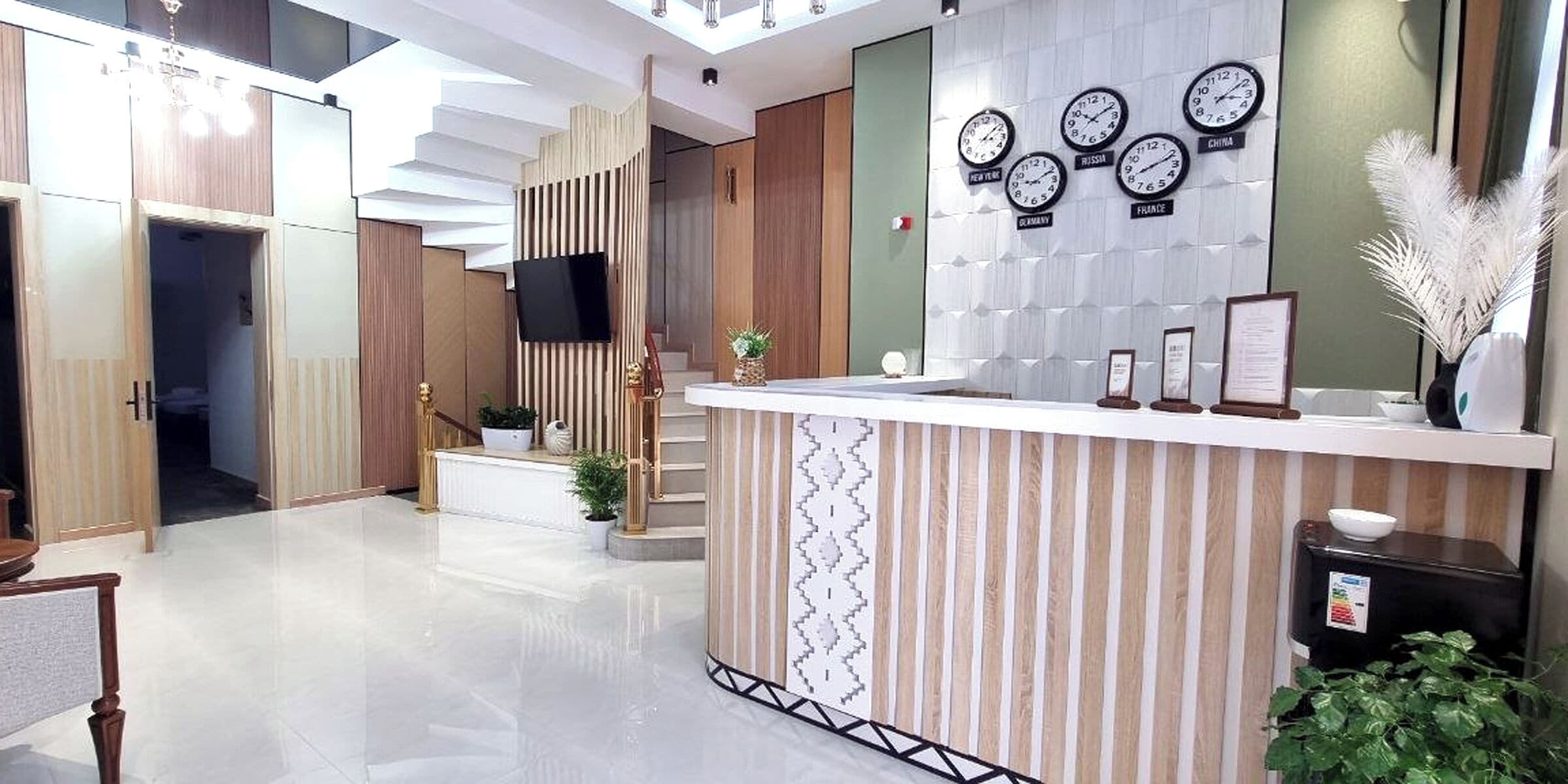 A reception area with a reception desk, a wall-mounted clock, and a staircase.