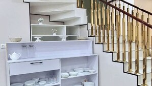 Un interior moderno con una escalera, repisas con vajilla y un diseño minimalista.