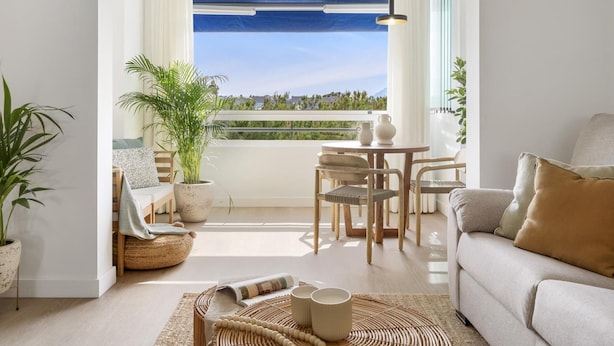 A modern living room with a balcony, a sofa, a dining table, and a potted plant. - Medina Garden 342 in Puerto Ban s - Marbella (Marbella)