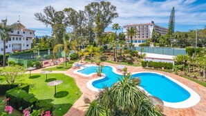 A resort with a swimming pool, lush greenery, and a clear blue sky. - Medina Garden 342 in Puerto Ban s - Marbella (Marbella)