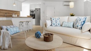 A modern living room with a sofa, a round coffee table, and a wicker chair. - 1 Bdr Playa Roc o 2 (Marbella)
