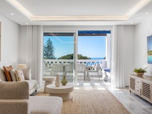 A modern living room with a sofa, coffee table, and a view of the balcony. - Casa Granada 2 44 in Puerto Ban s - Marbella (Marbella)