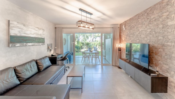 A modern living room with a sofa, TV, and dining area. - Sol de Mijas in Marbella (Mijas)