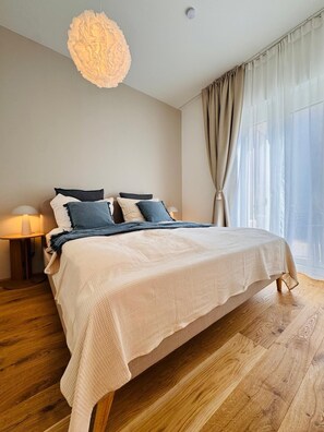 Ein Schlafzimmer mit einem großen Bett, einer Nachttischlampe und einer Pendelleuchte.