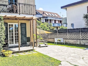 Ein Wohngebiet mit einem zweistöckigen Haus, einer Veranda und einem kleinen Garten.