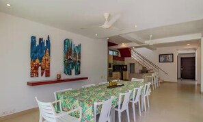 A dining area with a long table, white chairs, and ceiling fans. - Amazing TopSpot® 400 Meters From Manzanillo Beach! (Cartagena de Indias)