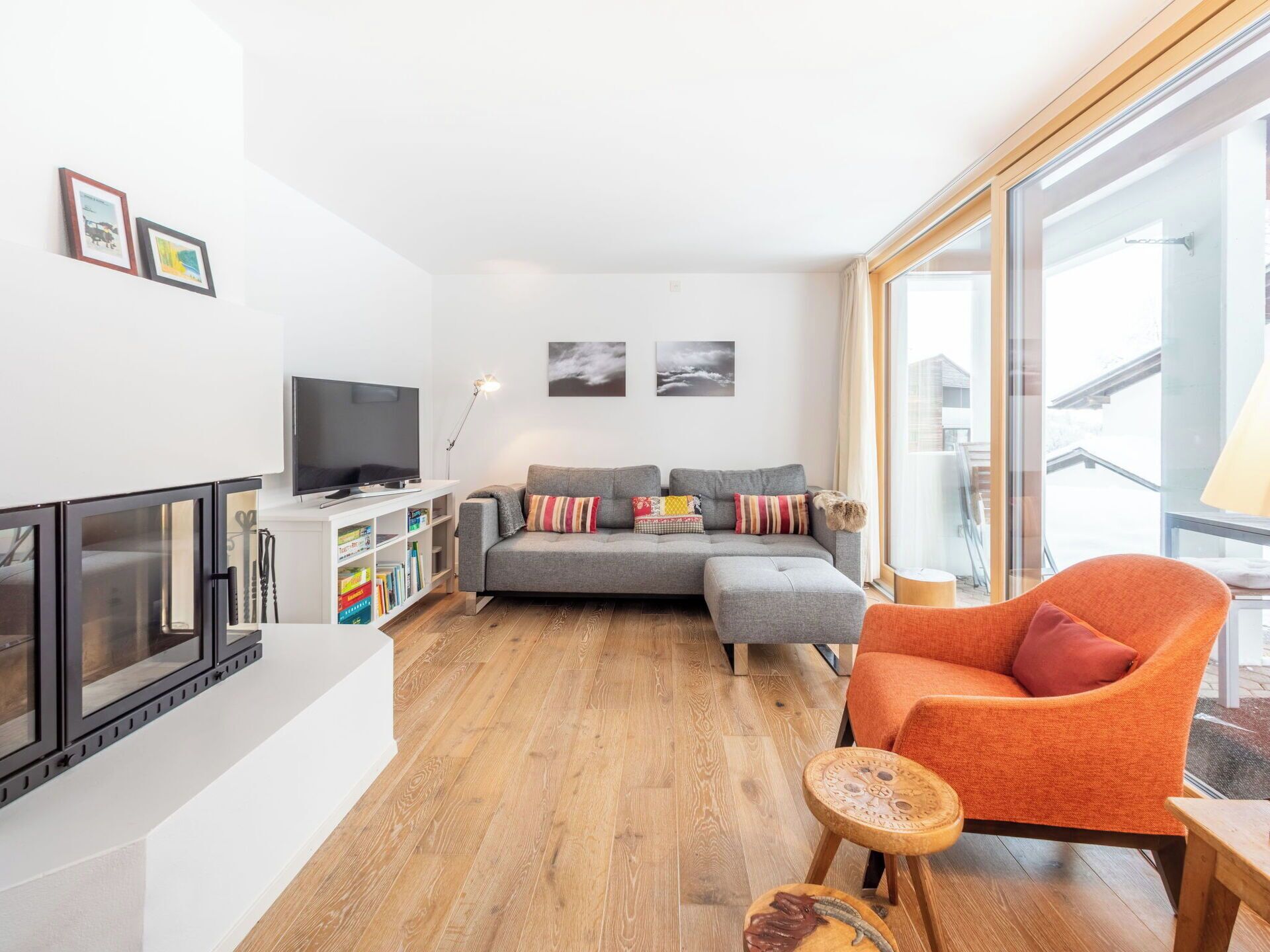 A modern living room with a sofa, a television, and a bookshelf.
