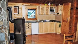 A compact kitchen with wooden cabinets, a microwave, and a stove.