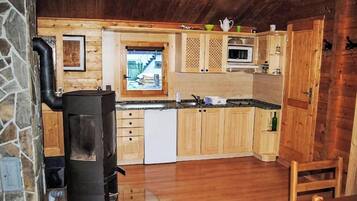 Une cuisine de taille réduite, dotée de meubles en bois, d’un four à micro-ondes et d’une cuisinière.