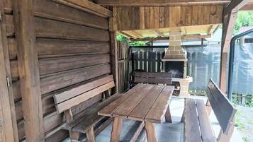 Un espace extérieur aménagé en bois, avec des bancs et une table.