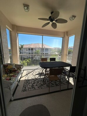 A covered patio with a table and chairs, a sofa, and a ceiling fan. - Sun Worshipper Cozy Condo Retreat (Fort Meyers)