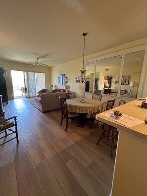 A spacious living area with a dining table, chairs, and a ceiling fan. - Sun Worshipper Cozy Condo Retreat (Fort Meyers)
