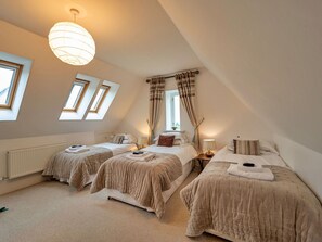 Ein Schlafzimmer mit zwei Betten, einem Dachfenster und einer Pendelleuchte.