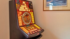 Ein Spielautomat mit verschiedenen Spieloptionen und einem Münzweckfach.