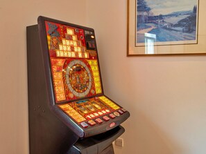 Ein Spielautomat mit verschiedenen Spieloptionen und einem Münzweckfach.