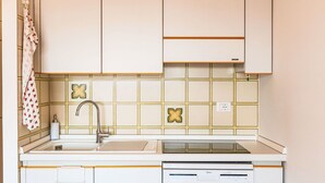 A compact kitchen with white cabinets, a sink, and a dishwasher. - Cosy apartment for 3 guests with WIFI and terrace (Sanremo)