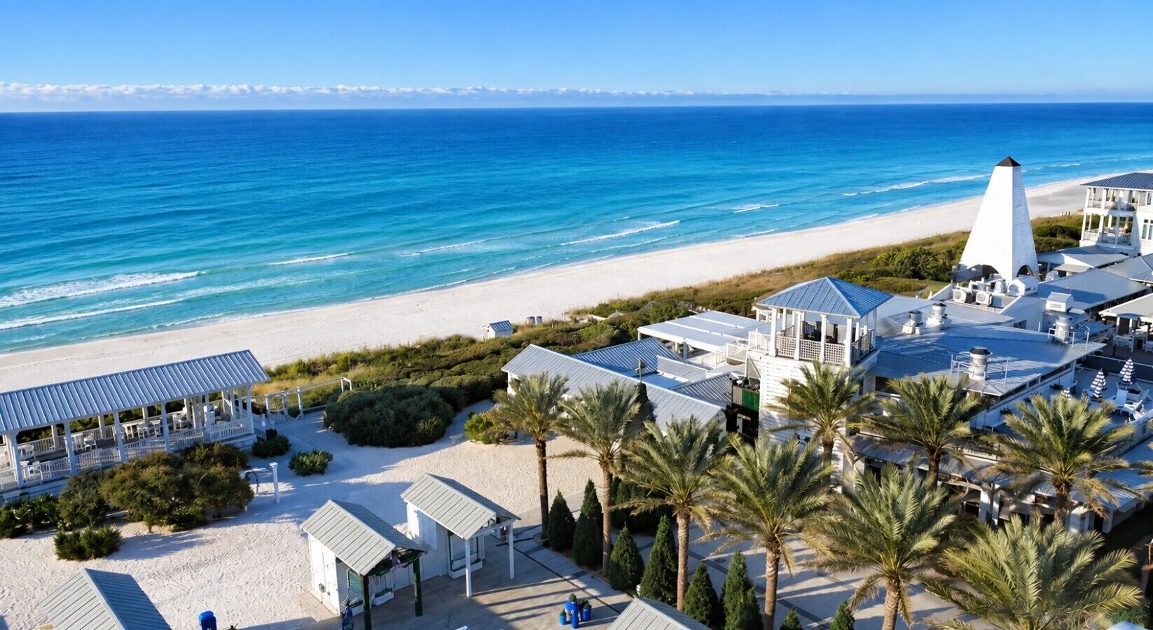 A coastal hotel with a beach view, multiple guest rooms, and a prominent lighthouse structure.